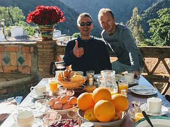 Foto vom Frühstückstisch von "Sierra y Mar" mit 2 zufriedenen Wanderern
