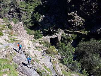 Foto von Wanderern in der Sierra Nevada mit alter Brücke übers Tal